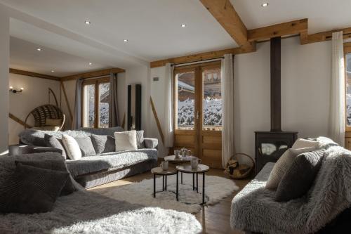 a living room with two couches and a table at Chalet Des Grands Vanays in Les Houches