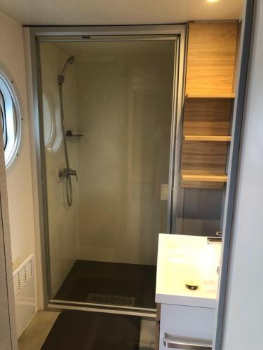 une salle de bain avec une douche avec un lavabo et une douche dans l'établissement Mobil Home Premium 6 personnes, à Torreilles