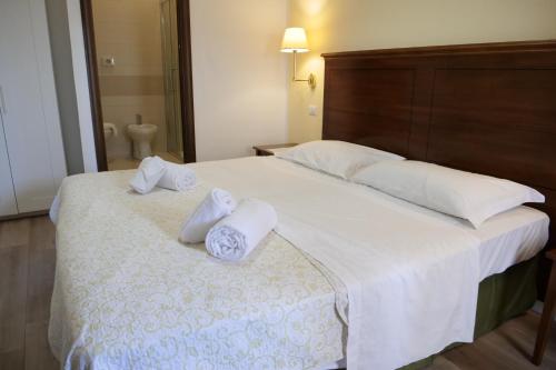 a bedroom with a large white bed with towels on it at Hotel Elios Tao in Taormina