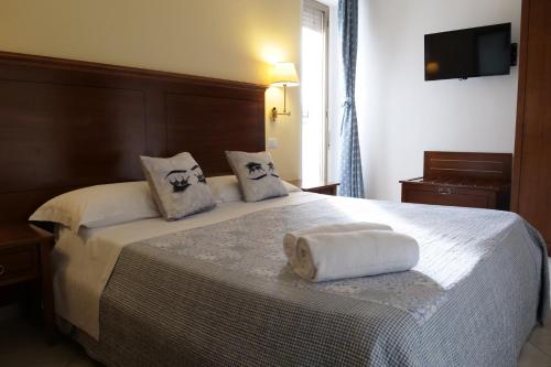 a bedroom with a bed with two towels on it at Hotel Elios Tao in Taormina