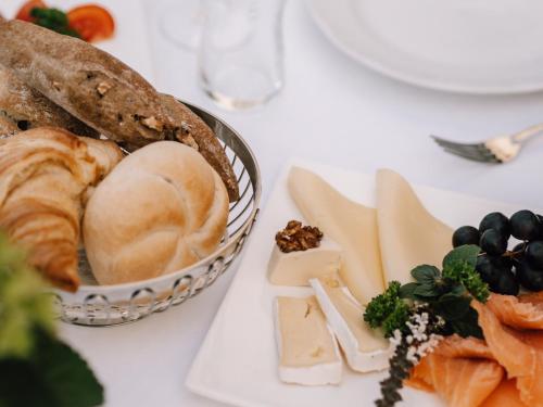 a white table with a plate of cheese and bread at Hotel Montjola Nova in Schruns-Tschagguns