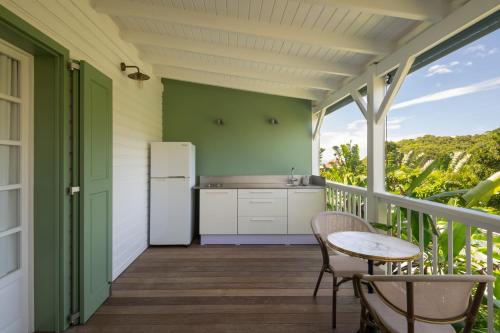 a balcony with a refrigerator and a table and chairs at 1493 lodge de charme le NINA in St Barthelemy