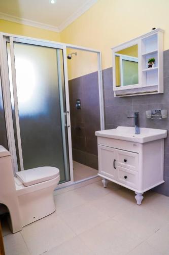 Un baño con inodoro, lavabo y ducha. en Starlight 4 bedroom golden view, en Naivasha