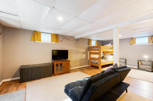 a living room with a couch and a tv and a bed at Welcome Home in North Conway