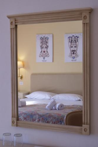 a mirror reflection of a bed in a bedroom at Hotel Elios Tao in Taormina