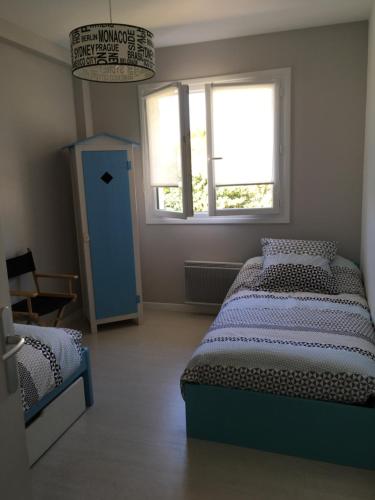 - une chambre avec 2 lits et une porte bleue dans l'établissement Villa œillets des dunes, à Capbreton