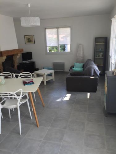 un salon avec un canapé et une table dans l'établissement Villa œillets des dunes, à Capbreton