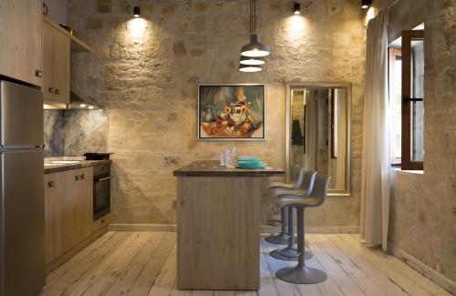 a kitchen with a bar with two stools in it at Cozy Stone House Petrino in Kriopigi