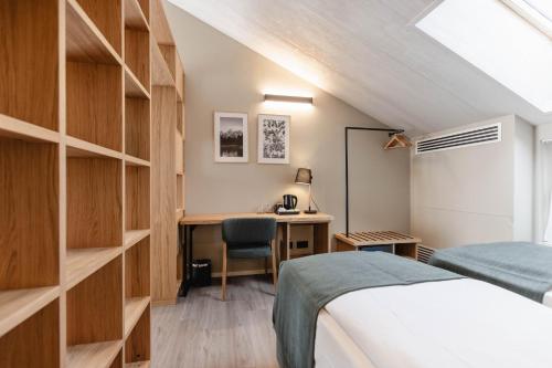 a bedroom with a bed and a desk with a chair at Terra Hotel Boutique in Tirano