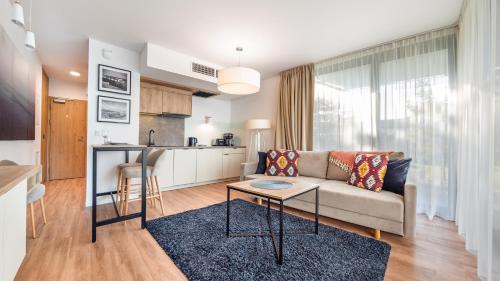 a living room with a couch and a table at Jantaris B2 in Mielno