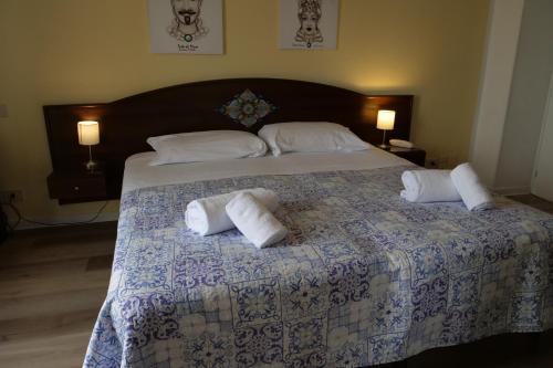 a bedroom with a large bed with towels on it at Hotel Elios Tao in Taormina