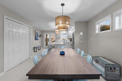 a dining room with a wooden table and blue chairs at Outer Banks Haven New Kitchen and New Outdoor Areas in Kitty Hawk Beach