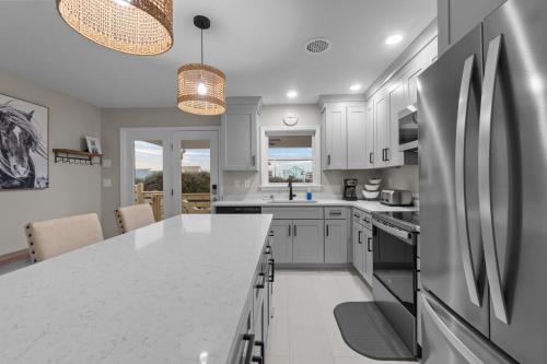 a kitchen with white cabinets and a white counter top at Outer Banks Haven New Kitchen and New Outdoor Areas in Kitty Hawk Beach