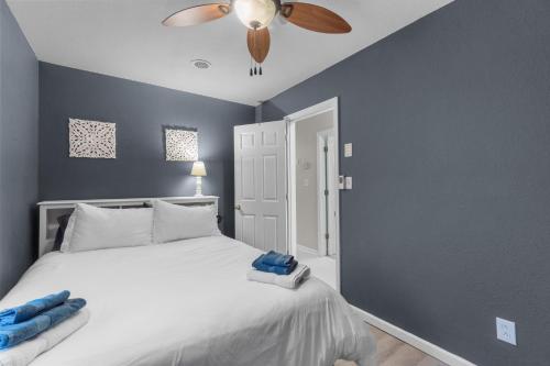 a bedroom with a white bed and a ceiling fan at Outer Banks Haven New Kitchen and New Outdoor Areas in Kitty Hawk Beach