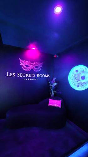 a purple room with a bed and a sign on the wall at Suite de luxe érotique chic in Coursan