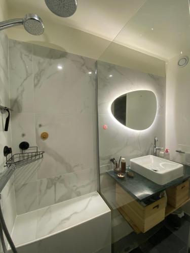 une salle de bain blanche avec une douche et un lavabo dans l'établissement Cosy et Arty, à Paris