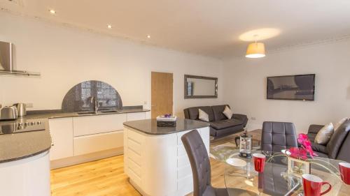 a kitchen and a living room with a table at Captains Quarters 4 Apartment in Plymouth