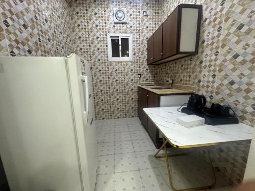 a small kitchen with a sink and a refrigerator at شقق راحتي جازان للشقق المخدومة in Jazan