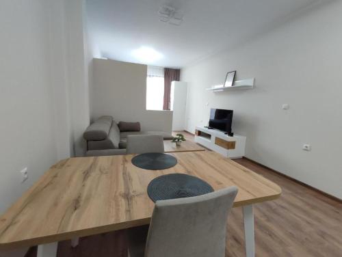 a living room with a wooden table and chairs at Pana Green Residence in Panagyurishte