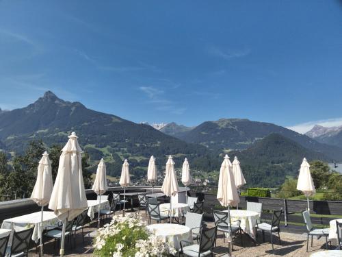 a group of tables and chairs with white umbrellas at Hotel Montjola Nova in Schruns-Tschagguns