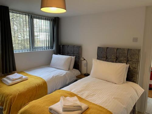 a room with two beds and a window at Waterloo 3 bed bungalow by the station in Plymouth