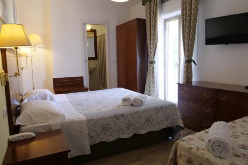 a bedroom with a bed with two towels on it at Hotel Elios Tao in Taormina