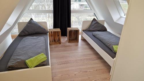 two beds in a room with two windows at Haus Unterkunft für Monteure in Budenheim, zentral gelegen in Budenheim