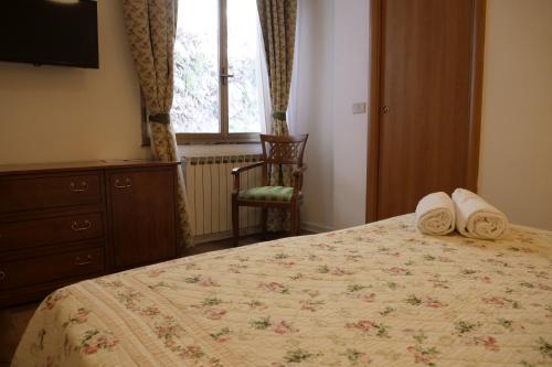 a bedroom with a bed and a chair and a window at Hotel Elios Tao in Taormina
