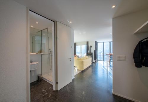 a bathroom with a glass door leading to a living room at Chalet Silence in Wengen