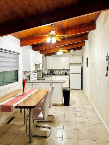 a kitchen with a wooden table and white cabinets at P&N Suites - DELUXE KING ROOM- PARIS in Edmonton