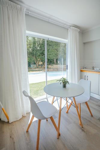 a white table and chairs in a room with a window at On Helderberg in Somerset West