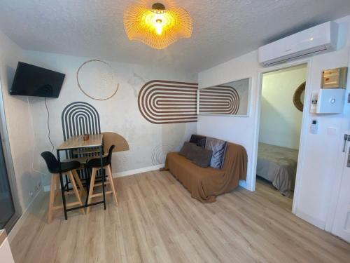 Cette petite chambre comprend une table, un lit, une table et des chaises. dans l'établissement Appartement climatisé en rez-de-chaussée 3 personnes max, au Cap d'Agde