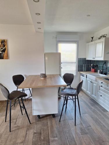 une cuisine avec une table, des chaises et un réfrigérateur dans l'établissement Parc de la roseraie, à Marseille