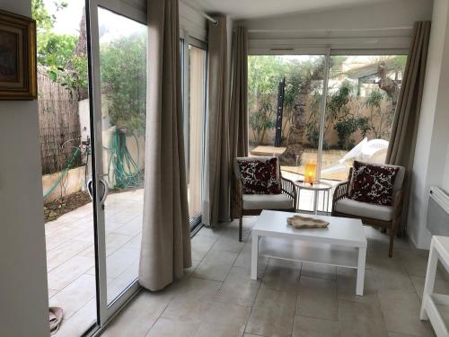 un salon avec deux chaises et une table dans l'établissement Maison bord de mer climatisée La Capte , Hyères, à Hyères