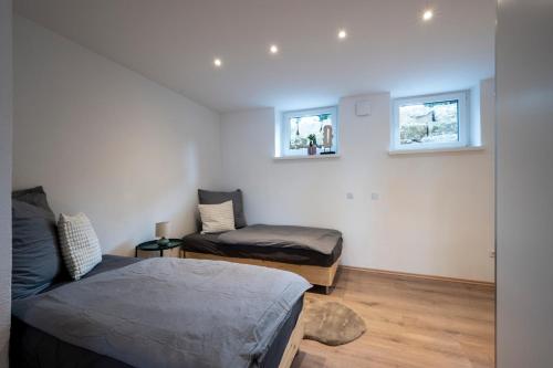 a bedroom with two beds and two windows at Modernes, stilvolles Apartment 1 in Memmingen