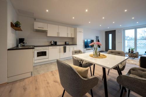 a kitchen and living room with a table and chairs at Modernes, stilvolles Apartment 1 in Memmingen