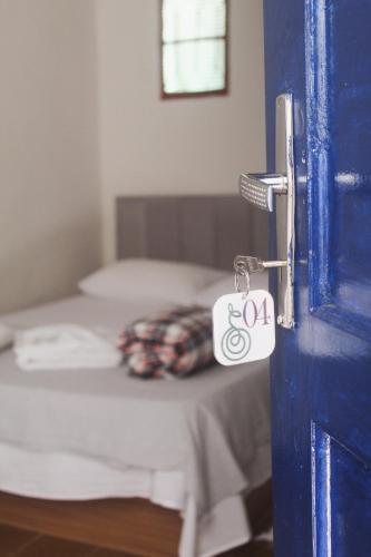 a room with a bed and a door with a key at Pousada Korui in Abraão