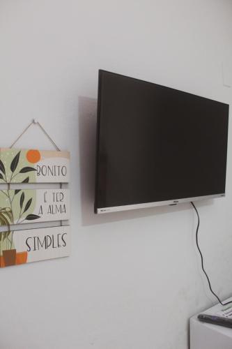 a flat screen tv hanging on a wall at Pousada Korui in Abraão
