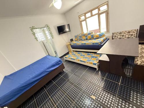 una habitación con dos camas y una mesa y un sofá en Pie en la arena de la playa Tupi, en Samaritá