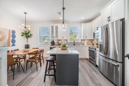 a kitchen with a dining table and a refrigerator at Luxury Stylish 3BR Oasis - Tampa Retreat in Tampa