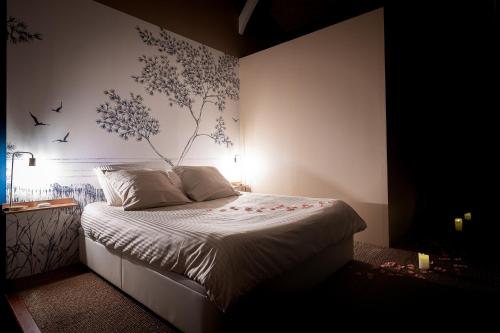 une chambre avec un lit avec une fresque florale sur le mur dans l'établissement Logement romantique avec jacuzzi privatif, à Biscarrosse