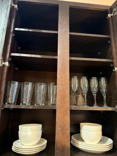 a shelf with plates and wine glasses on it at Downtown Houston Retreat with Free Parking in Houston