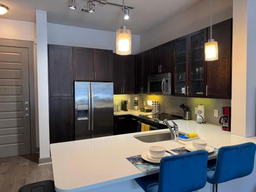 a kitchen with a sink and a counter with blue chairs at Downtown Houston Retreat with Free Parking in Houston