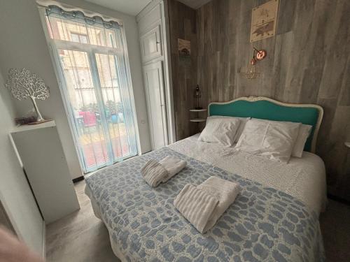 una camera da letto con un letto con due asciugamani sopra di 3 pieces avec terrasse entre plage et centre ville ad Arcachon