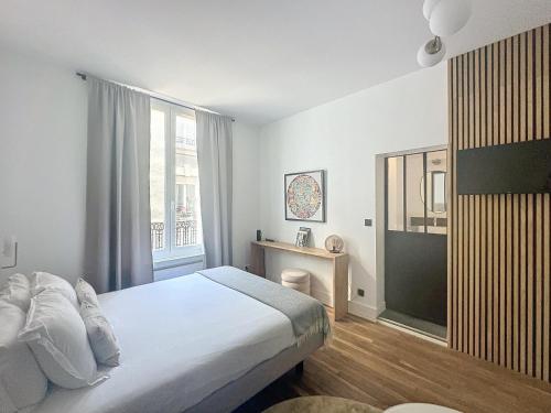 une chambre avec un lit et une grande fenêtre dans l'établissement So Guest, Clou dans le fer, modern suite near cathedral, à Reims