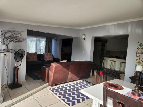 a living room with a couch and a table at 25 On Main Struisbaai in Struisbaai