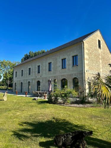 un grand bâtiment en briques avec une pelouse devant lui dans l'établissement Domaine de L'étang, à Fresnoy-la-Rivière