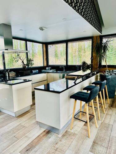 une cuisine avec un comptoir et des tabourets. dans l'établissement Domaine de L'étang, à Fresnoy-la-Rivière