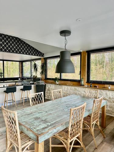 une salle à manger avec une table et des chaises en bois dans l'établissement Domaine de L'étang, à Fresnoy-la-Rivière
