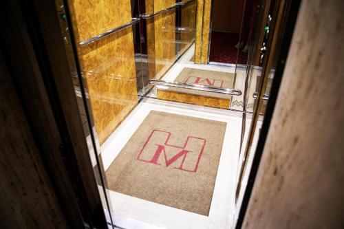 an open door with the letters k on the floor at Hotel Milano Pool & Garden in Salice Terme